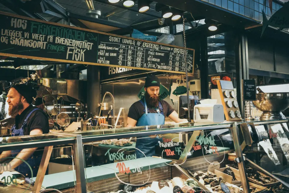 man standing behind glass display counter